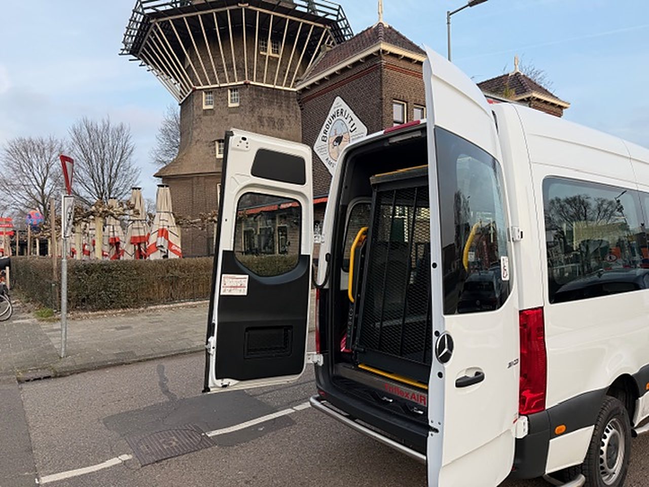 Rolstoelbus met geopende deuren bij een molen in Amsterdam