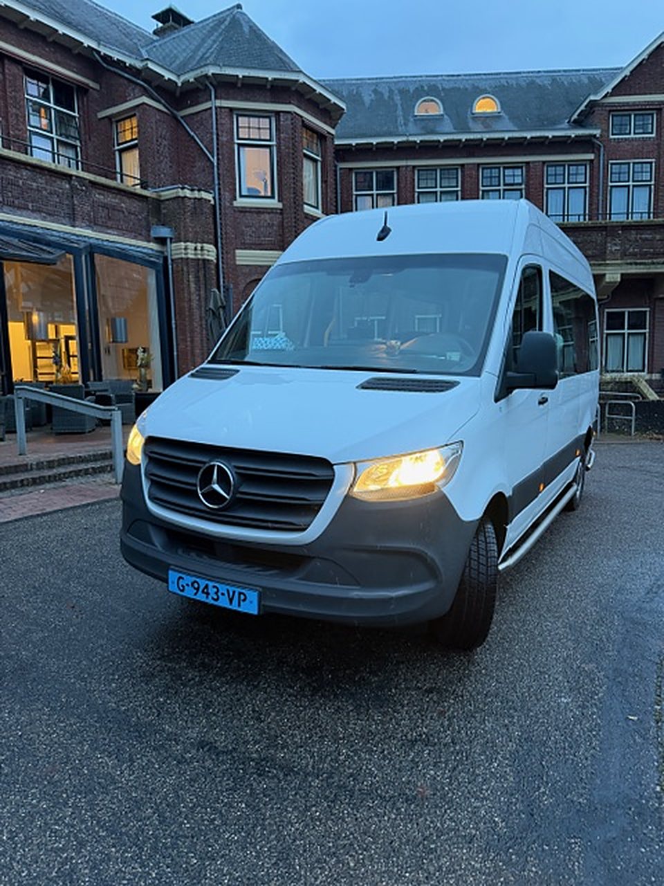 Rolstoelbus voor een gebouw van rode baksteen