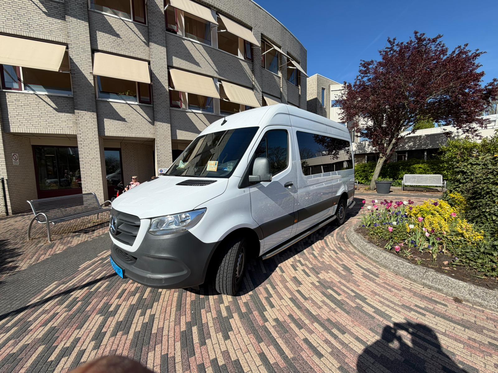 Rolstoelbus in de zon voor een gebouw